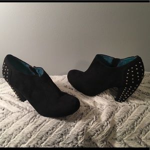 Black suede-like booties with gold studded heels.